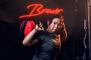 Fitness Athletes Commercial photography - portrait of a instructor carrying a sand bag