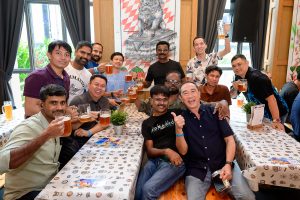 Rolls-Royce employees raising beer glasses at Oktoberfest 2026 in Singapore